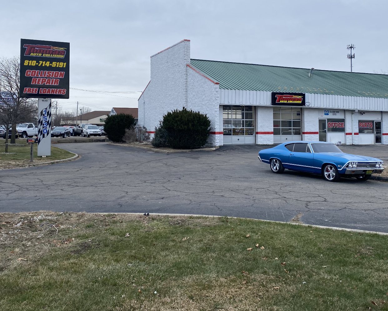 Thomas Auto Collision shop with a classic car out front